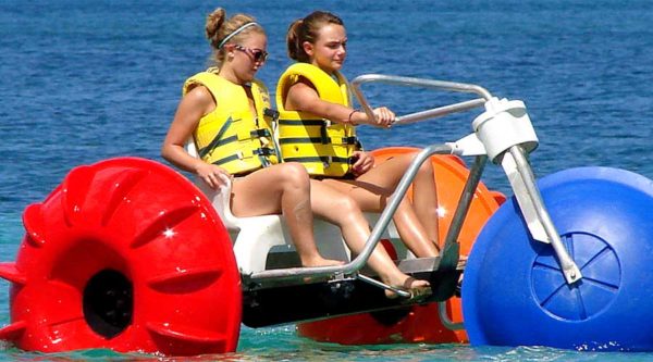 Aqua-Cycle™ Water Trikes with two girls peddling in the ocean Aqua-Cycle™ Water Trikes with two girls peddling in the ocean
