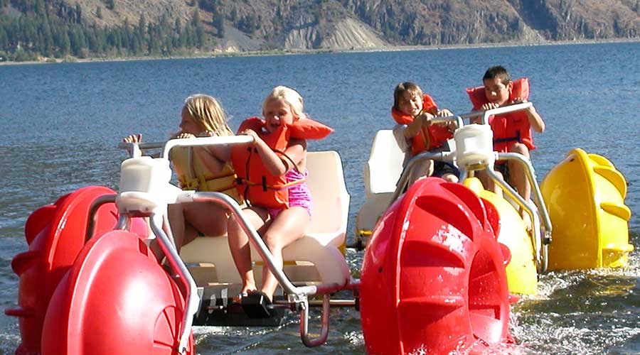 Yellow and red Aqua-Cycle™ Water Trikes at a lake resort or youth camp Yellow and red Aqua-Cycle™ Water Trikes at a lake resort or youth camp